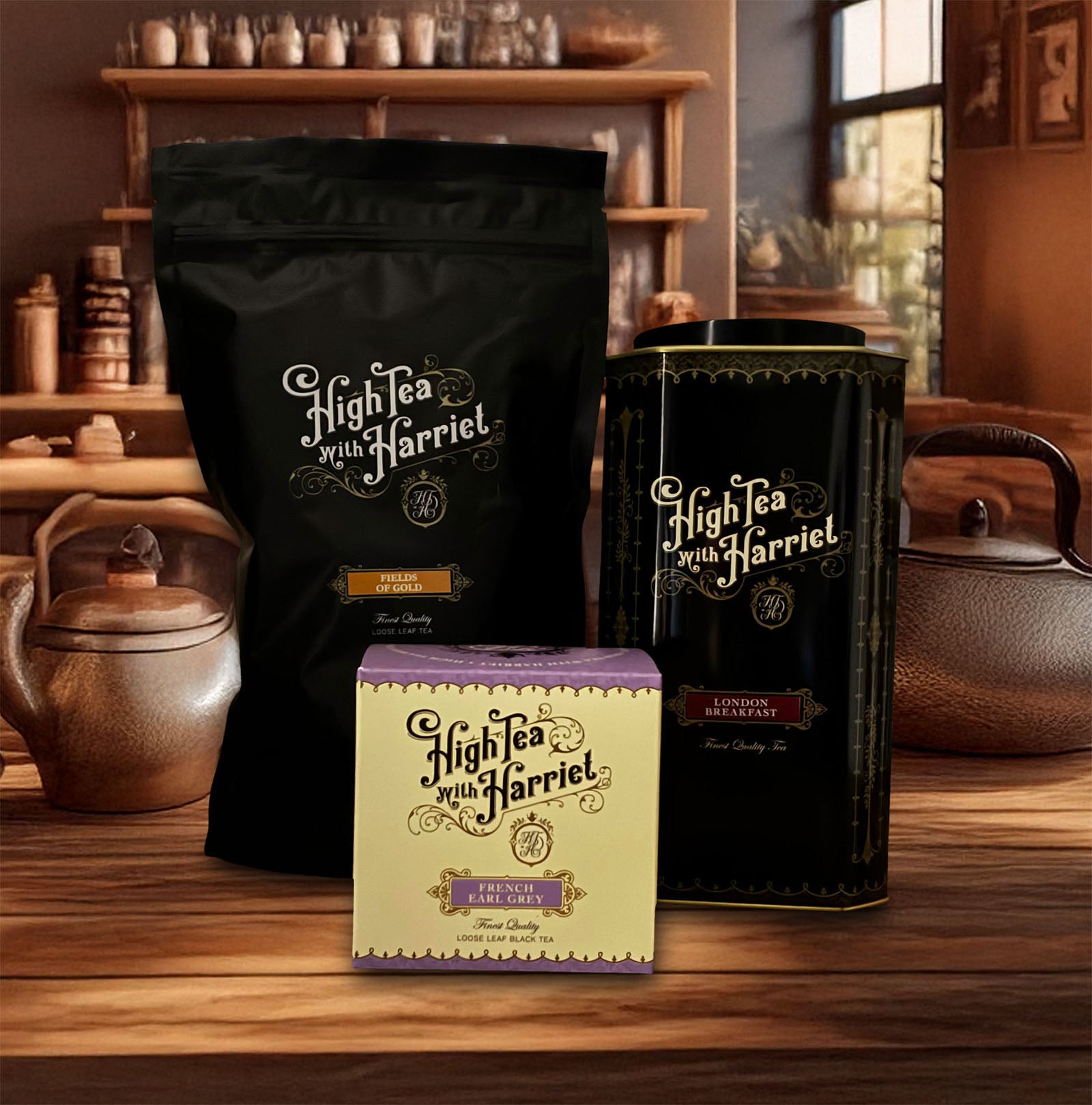 High Tea with Harriet packaged teas displayed on a wooden counter, including a black pouch of Fields of Gold, a tall black tin of London Breakfast, and a cream and purple box of French Earl Grey, with teapots and shelves in the background.