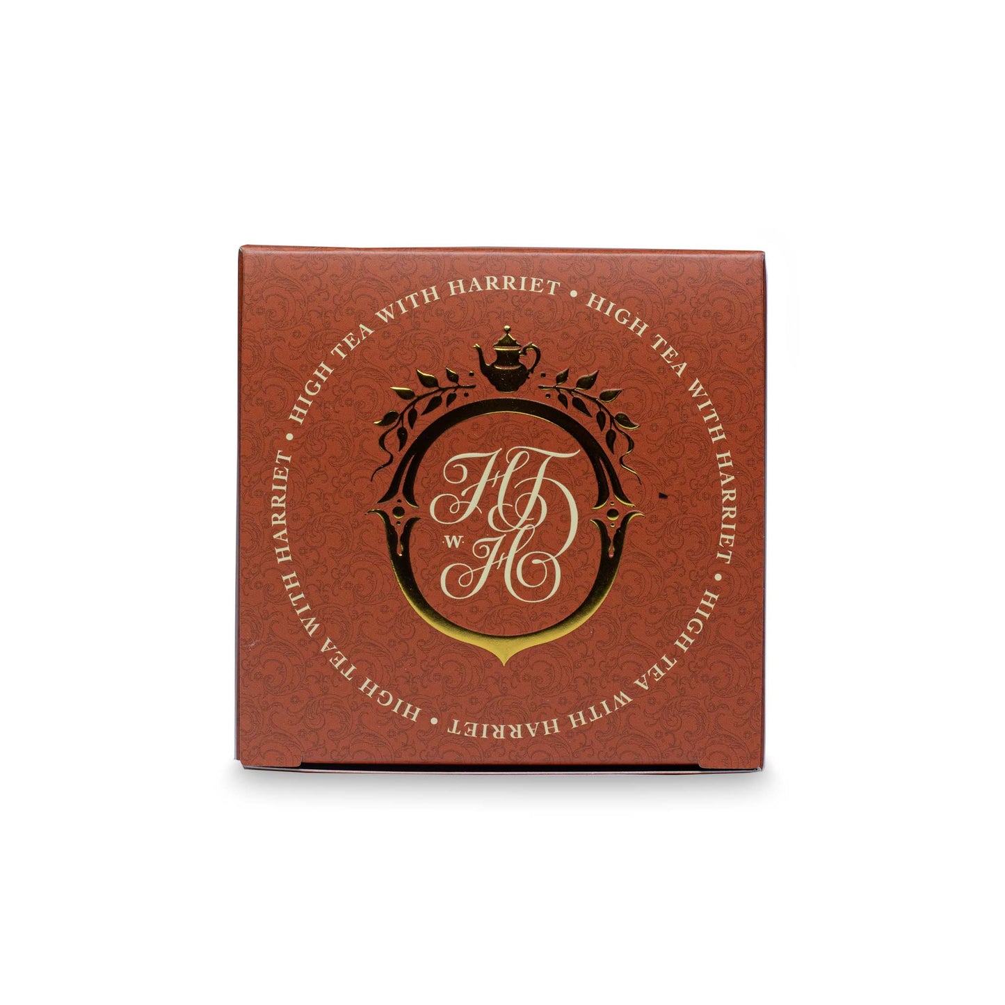 Top view of High Tea with Harriet Morning Tea box with gold crest and branding on copper background