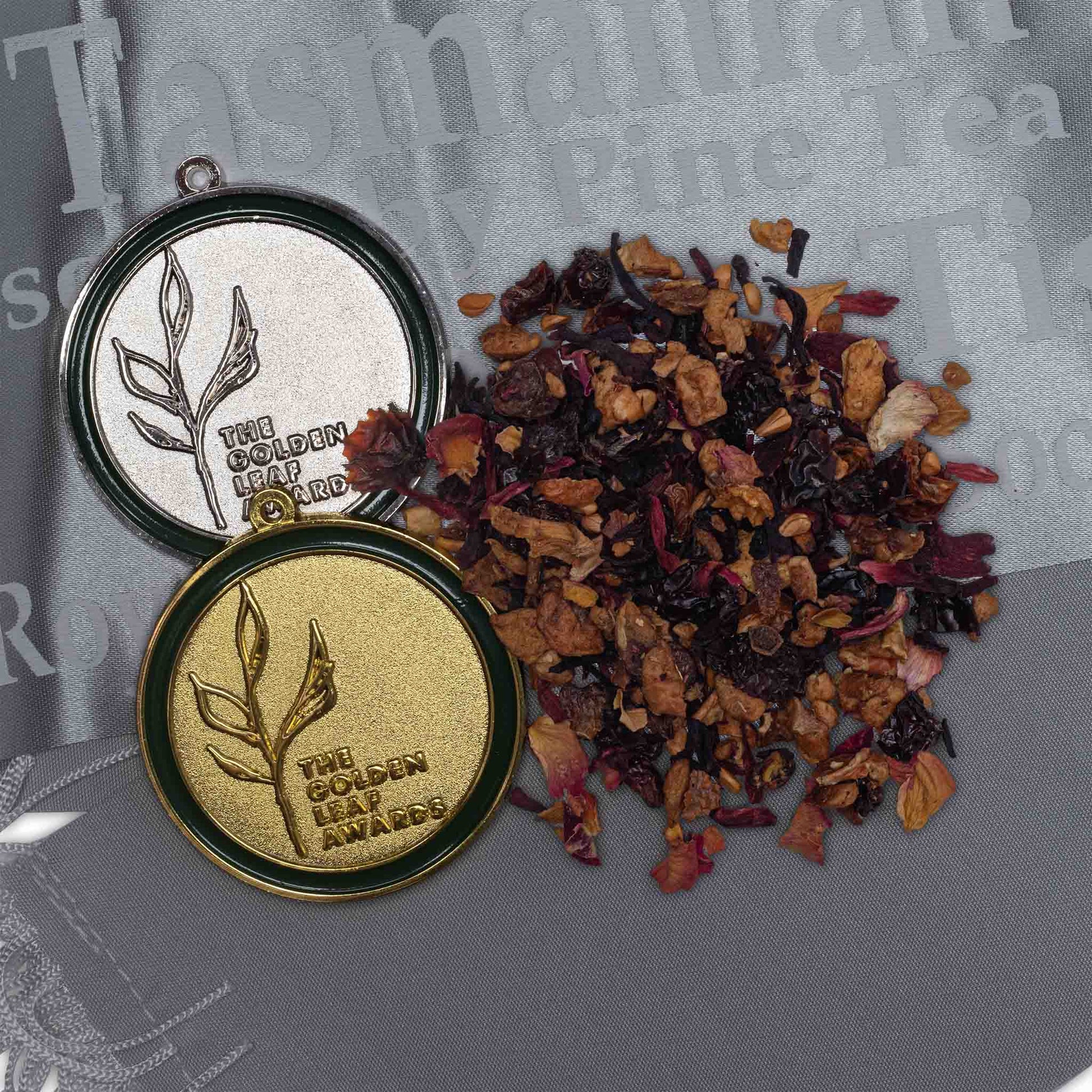 Award-winning Peach Blush tisane by High Tea with Harriet beside gold and silver Golden Leaf Awards medals